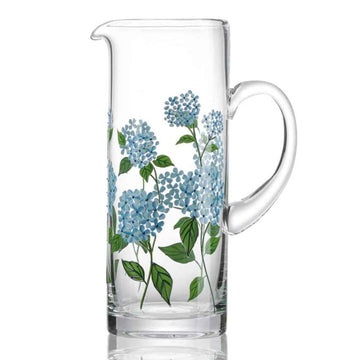 Clear glass pitcher with blue floral design on a white background