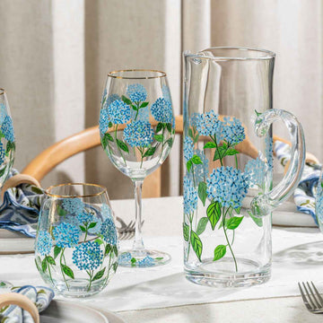 Clear glassware with blue floral designs on a table setting.