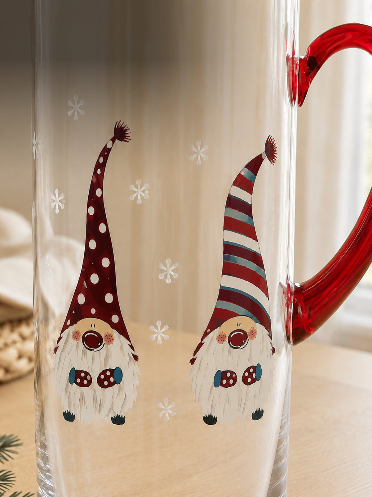 Close-up of the hand-painted Christmas gnome pitcher showing the red glass handle and a pair of painted gnomes