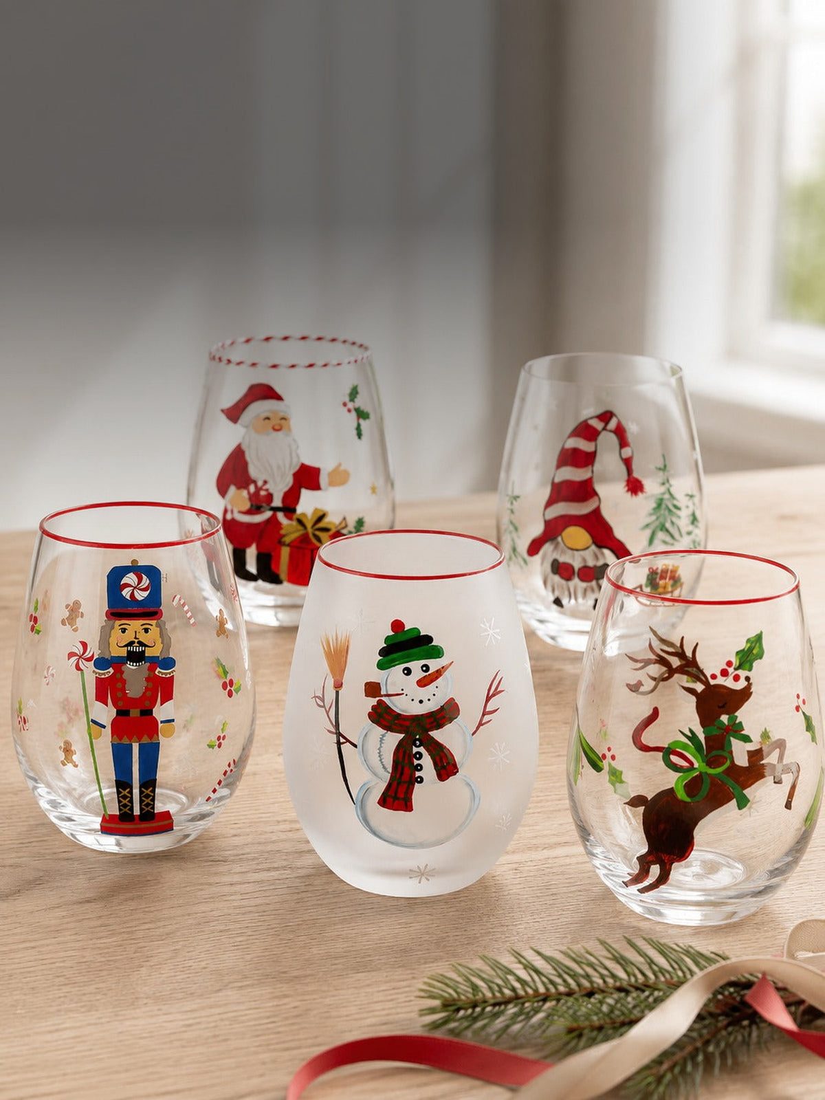 The hand-painted Christmas collection - nutcracker, frosted snowman, reindeer and gnome stemless wine glasses in daylight