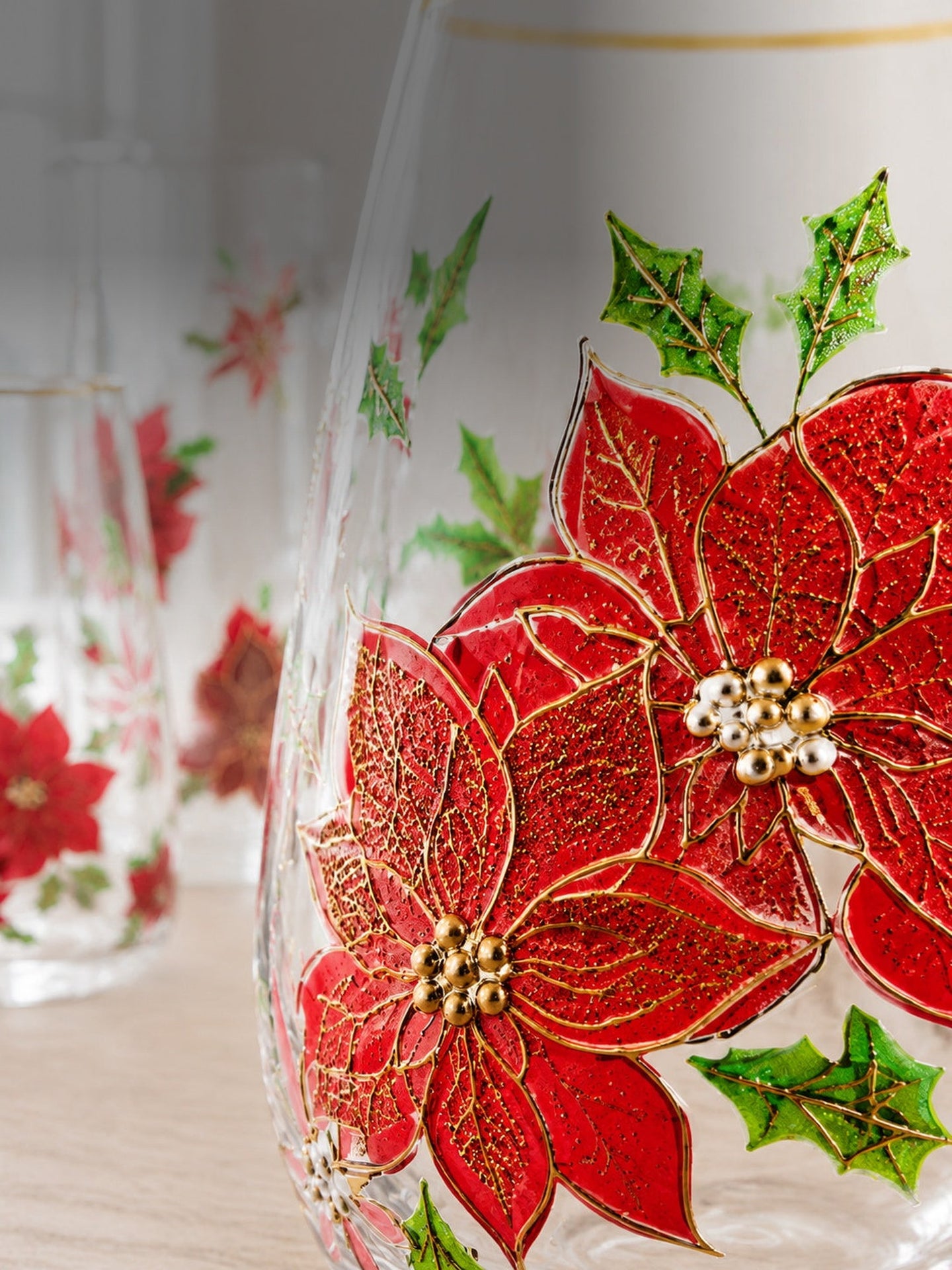 Daylight macro of the raised hand-painted poinsettia with gold veining on the glass