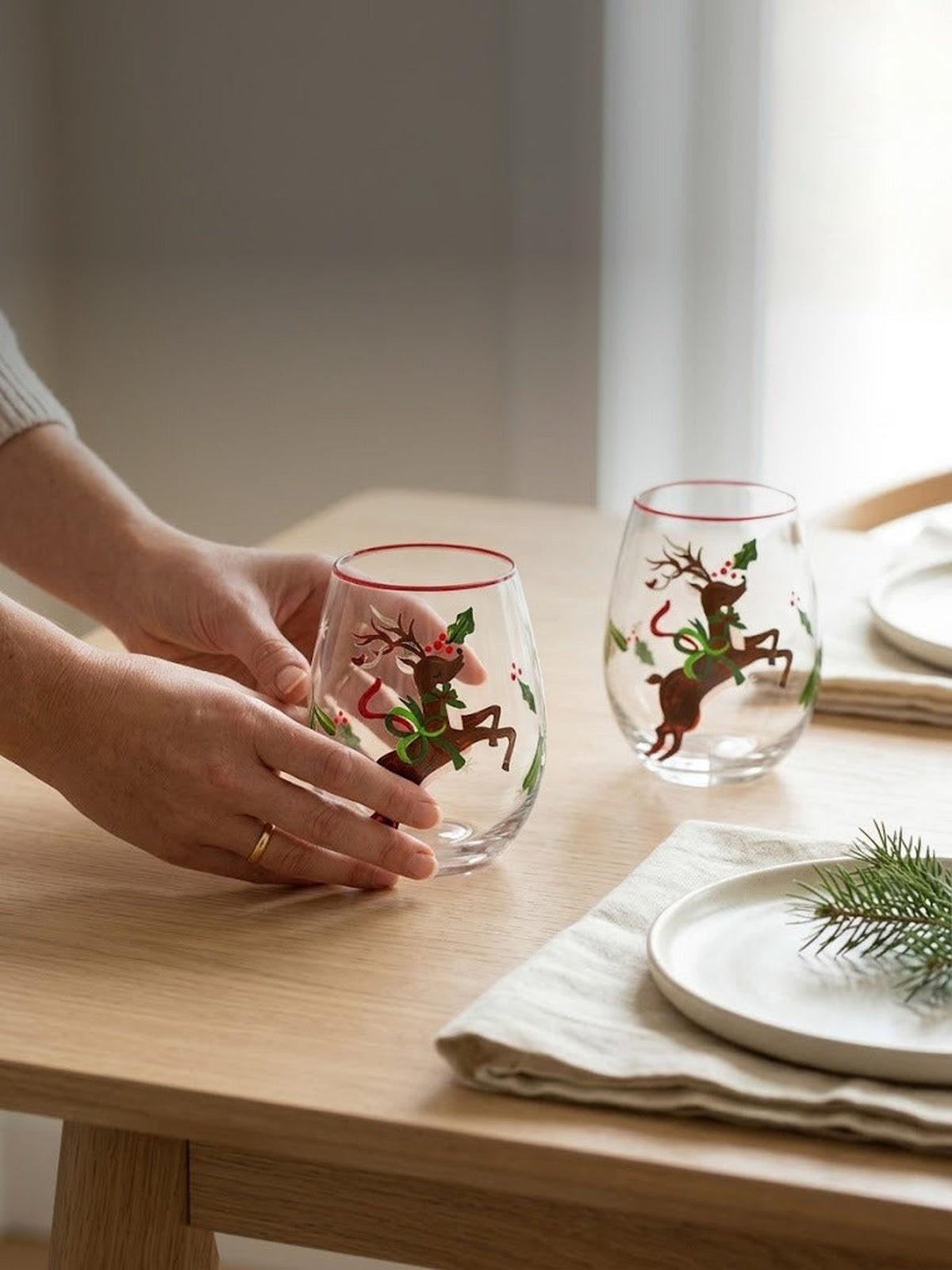 Setting a holiday table with hand-painted reindeer stemless wine glasses