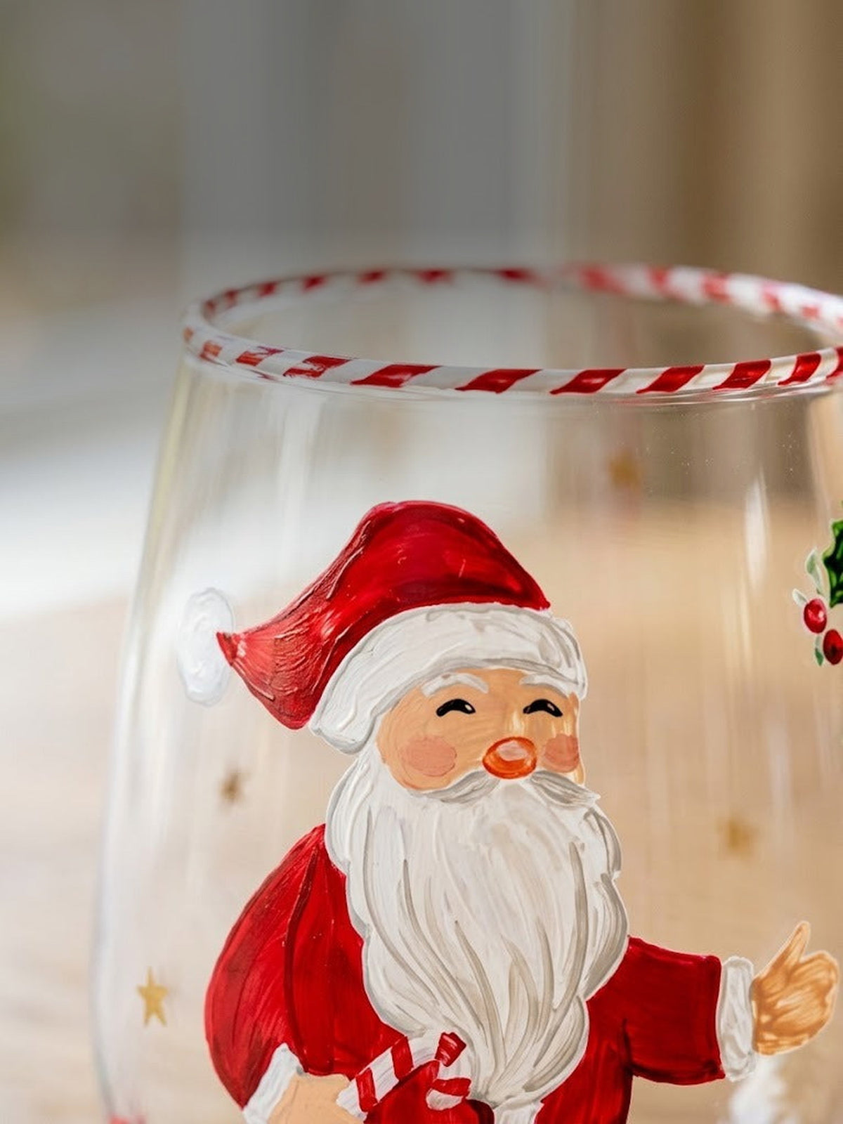 Macro detail of the hand-painted Santa and candy cane striped rim on clear glass